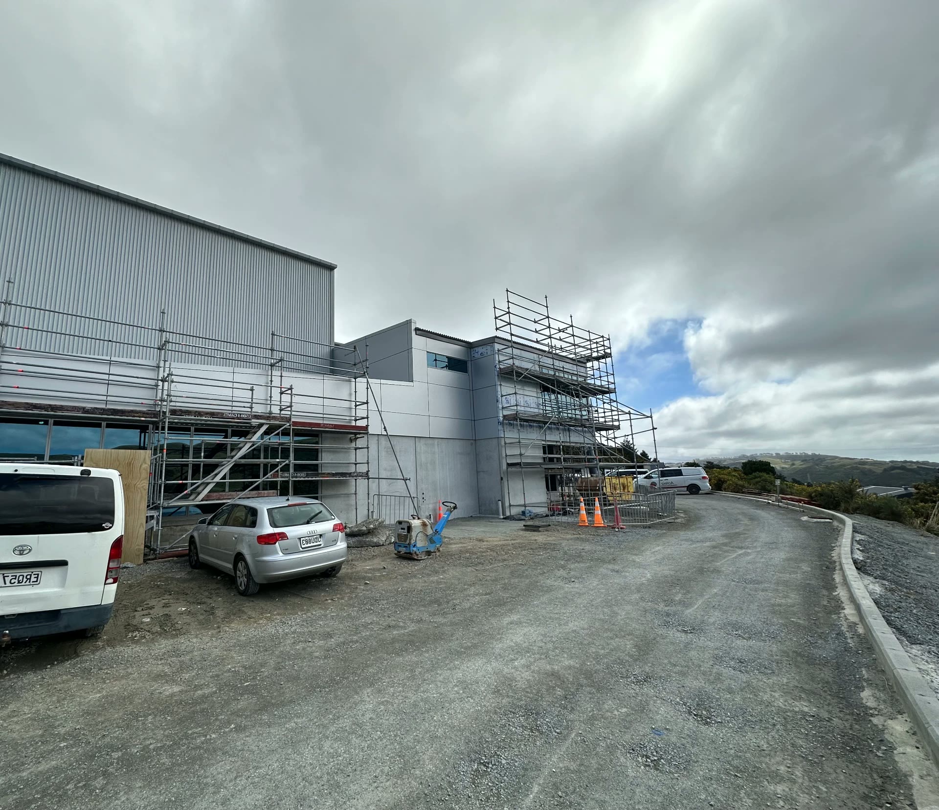 Commercial building mid-clad with scaffolding and grey panel cladding